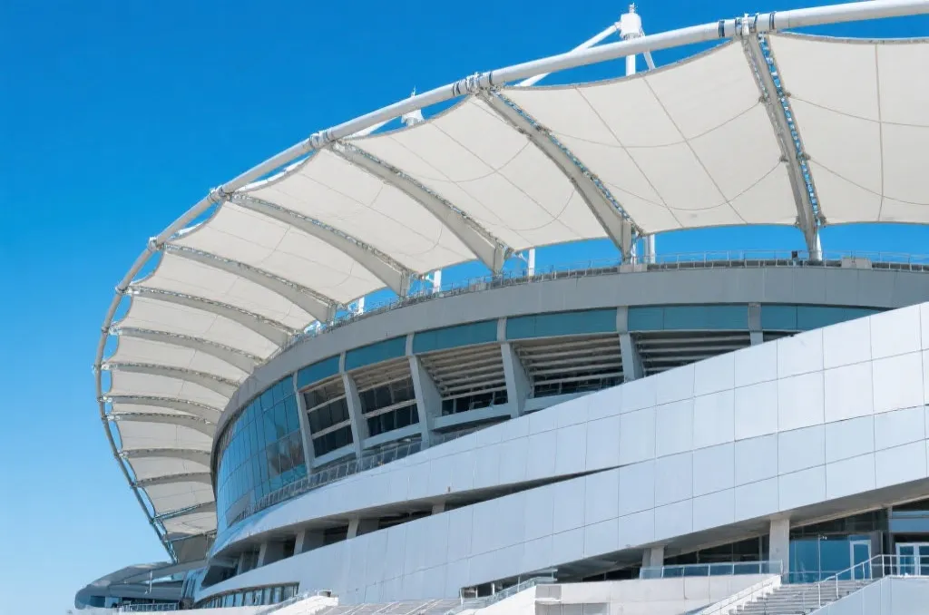 A futuristic stadium with a retractable roof, modern architecture under a clear blue sky